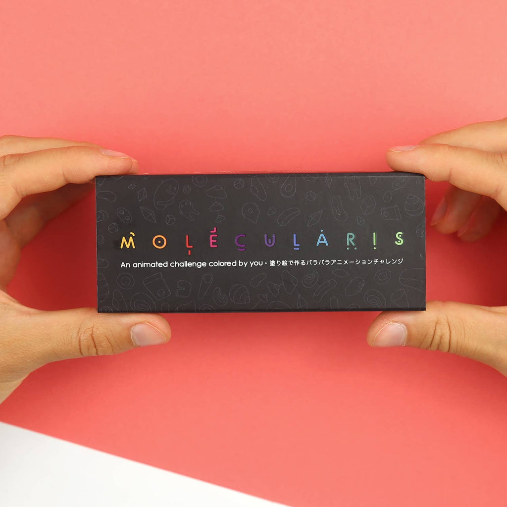 Molecularis-Flipbook neben verschiedenen Malwerkzeugen auf einer hellen Tischfläche.