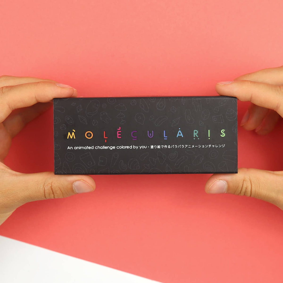 Molecularis-Flipbook neben verschiedenen Malwerkzeugen auf einer hellen Tischfläche.